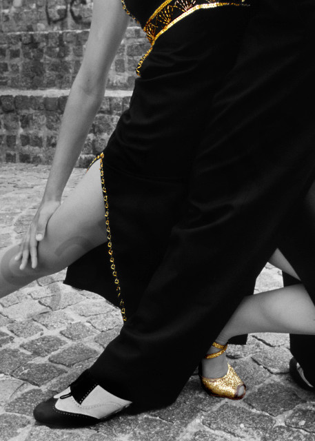 Lower part of Tango dancers intertwined in selective gold color