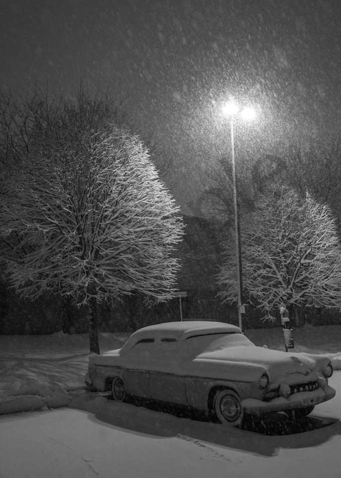 Snow fall covers an antique car