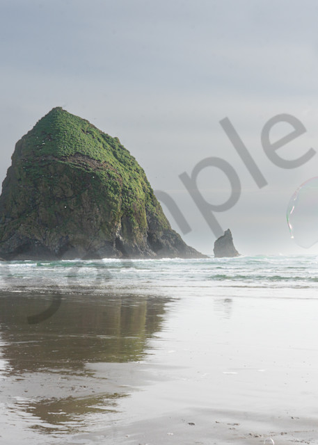 Little girl chases giant bubbles near Haystack Rock in photo for sale by Barb Gonzalez Photography.