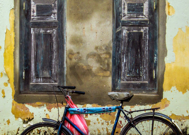 Fine art photograph of old bike under colonial window and crumbling wall