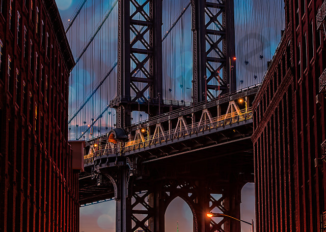 Manhattan Bridge under a decorative, twilight sky.