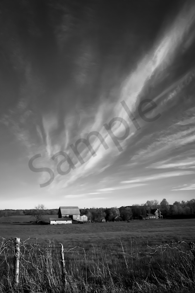 Black & white country and ruralscape photograph of dramatic clouds over a farm and barn in rural Ontario, for sale as fine art by Sage & Balm
