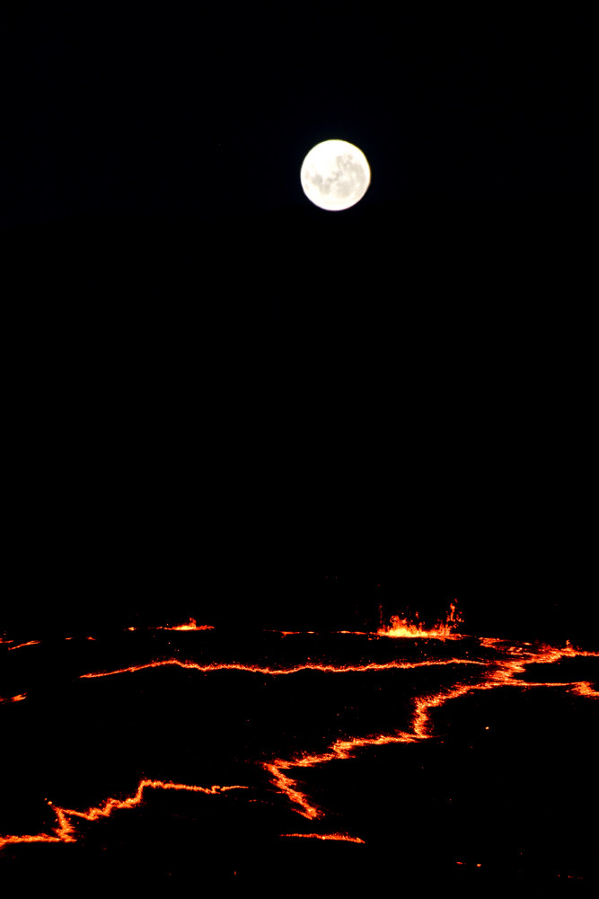 Full moon rising over volcano rim.