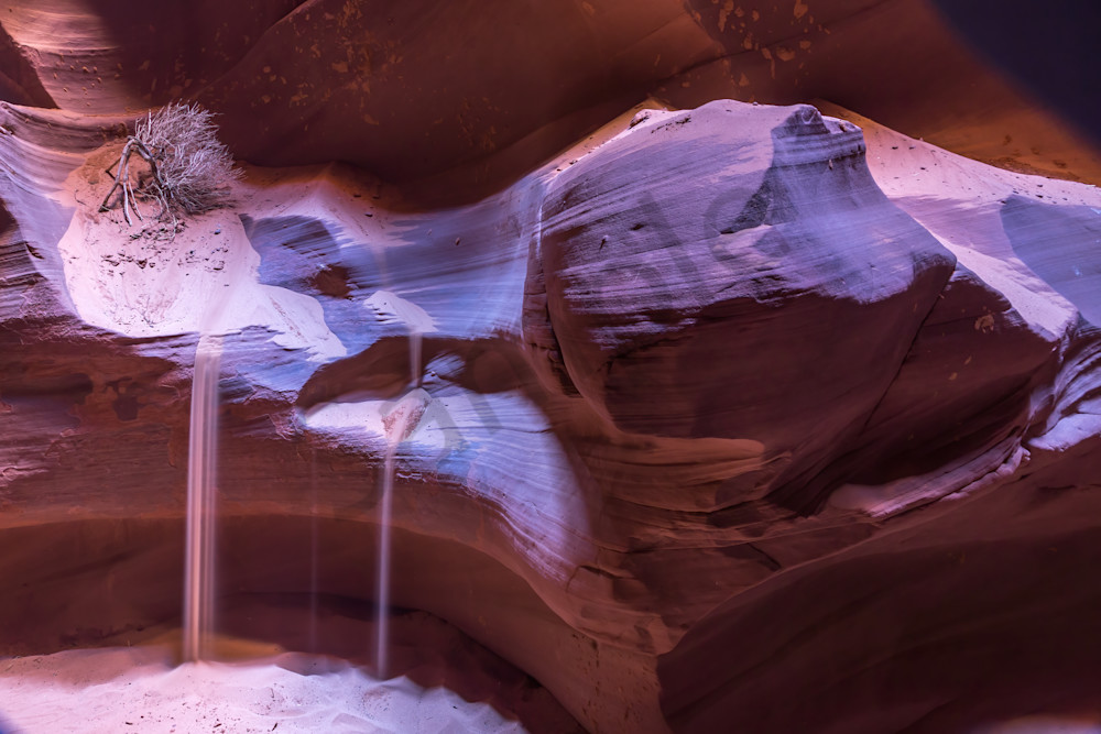Sand pours off a ledge in slot canyon