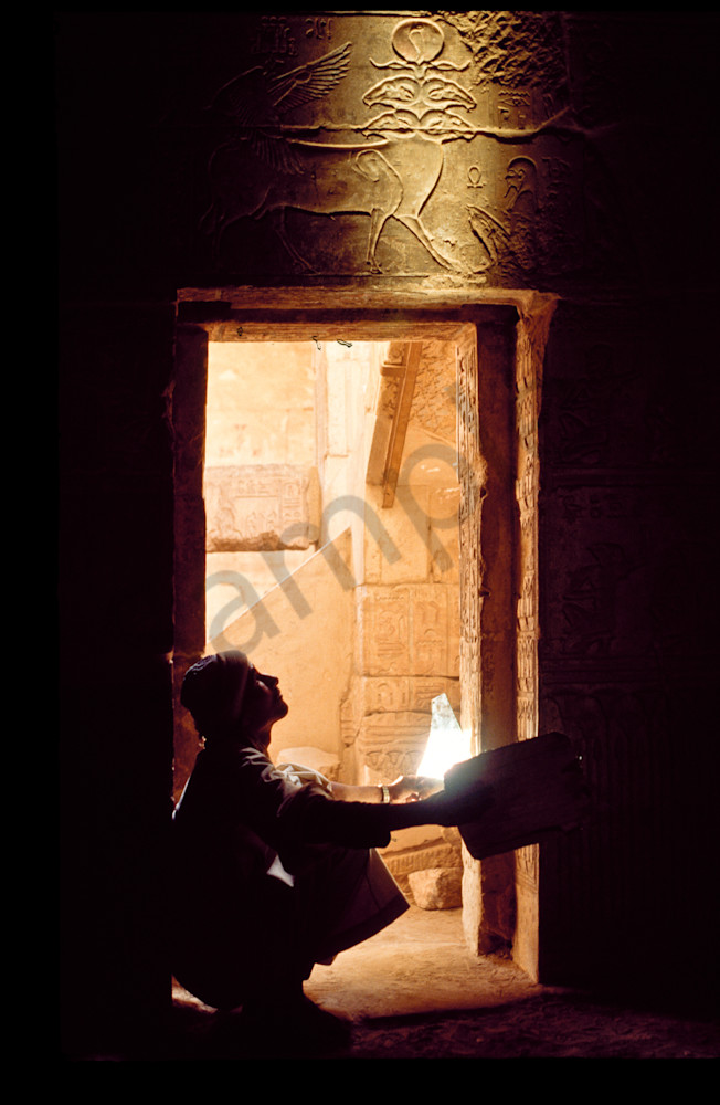Artifacts on tomb interior at Deir El-Medina "Thebes" being lit by use of mirrors to reflect the sunlight deep into the tomb.  Luxor, Egypt