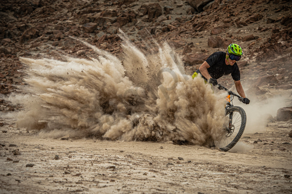Photographs of Matt Hunter kicking up dust making a wave of dirt while riding his mountain bike through a field of boulders in the foothills of Puerta Inka Peru