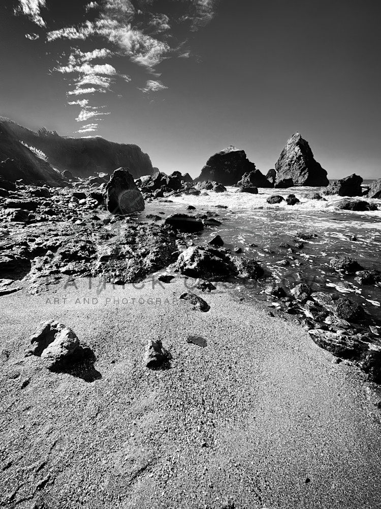 Pacific Ocean waves grind the Luffenholtz Beach boulders and cliffs into gravel in Humboldt County, California.