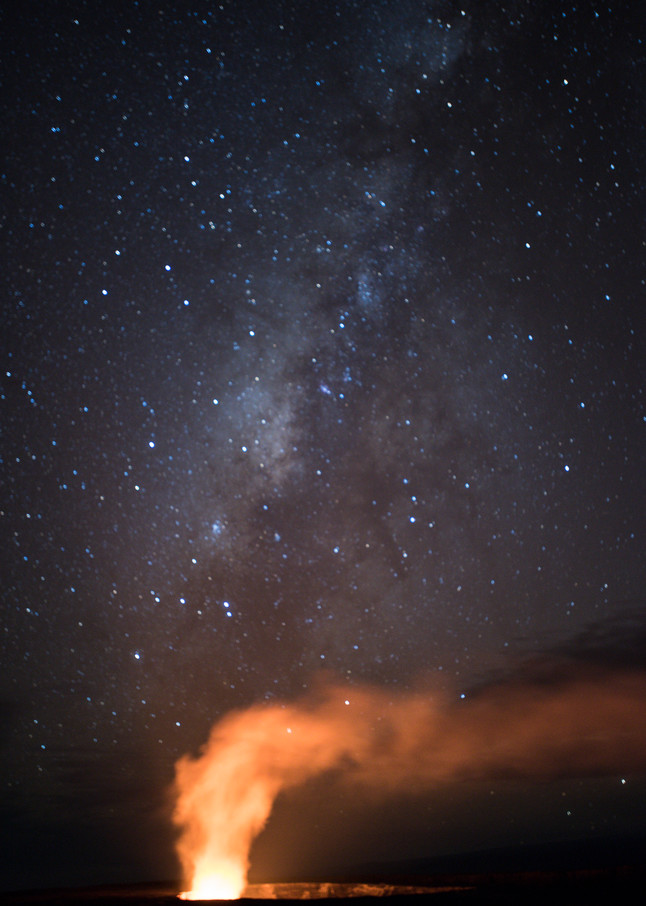 Hawai'i Volcanoes National Park, Big Island of Hawaii, Hawaii; the night sky, stars and the milky way are visible above the glowing lava lake within the Halemaʻumaʻu crater on Kīlauea volcano