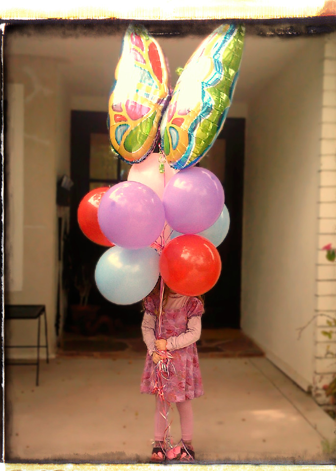 A birthday girl with eight balloons