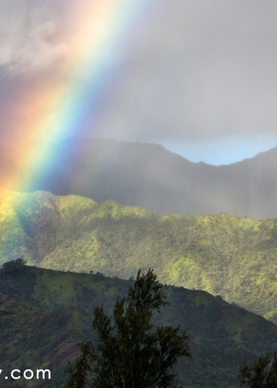 Early morning rain shower and rainbow over Hanalei Bay on Kauai