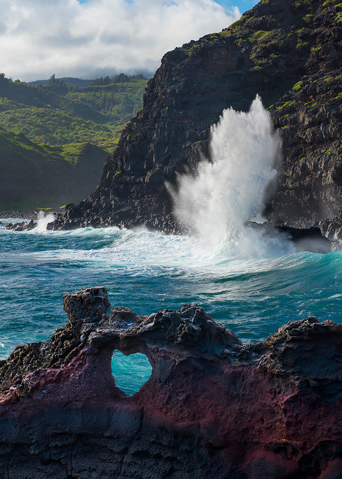 Color photo of powerful wave breaks in front of heart rock