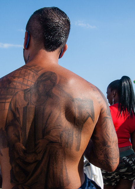 A tattoed man on the boardwalk at Coney Island.