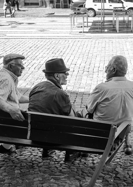 Old men converse on a broken bench
