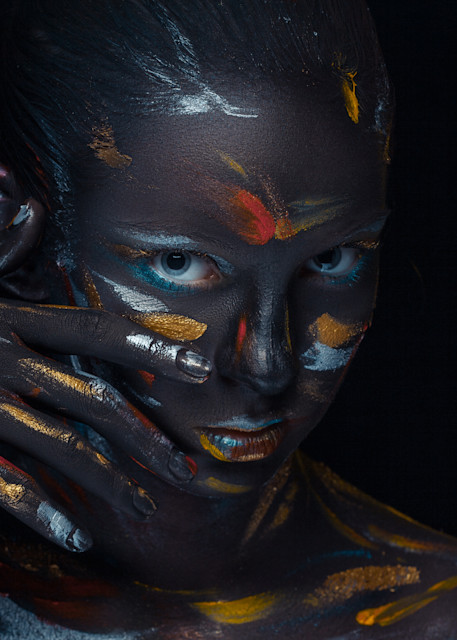 Portrait of a young woman who is posing covered with  black paint