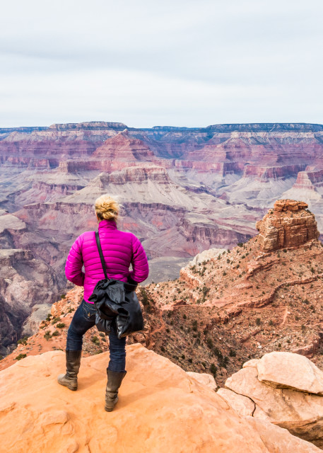 A woman standing at the edge of a precipice Grand Canyon National Park, Arizona, USA.
