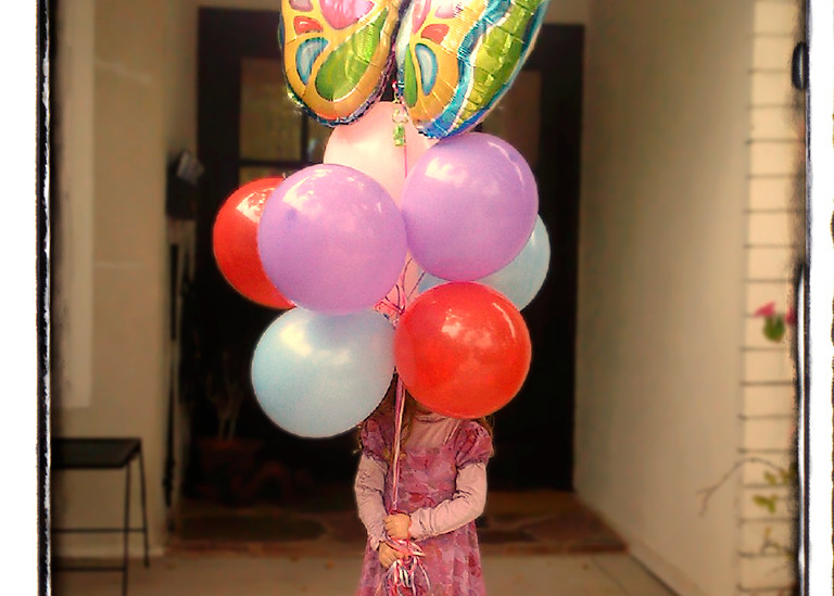 A birthday girl with eight balloons