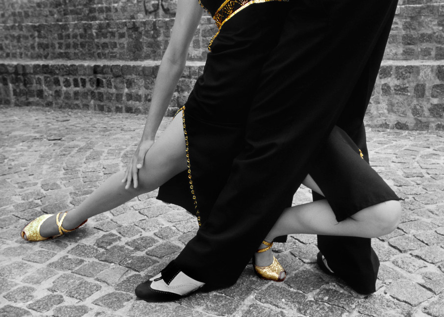 Lower part of Tango dancers intertwined in selective gold color