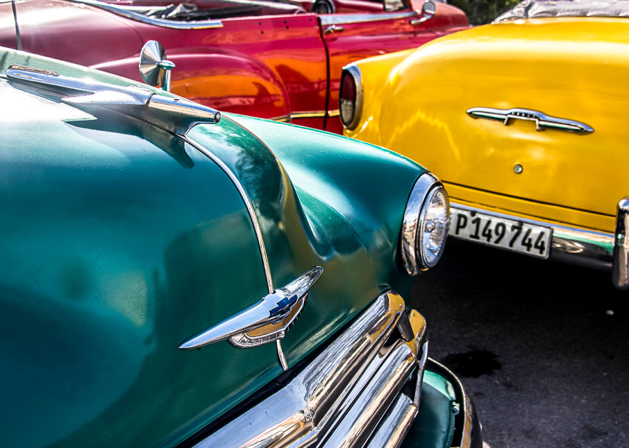 Fine art photograph of Red, yellow and green classic cars in partial view together