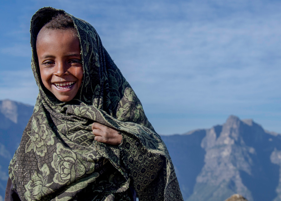 Art photograph portrait of smiling Ethiopian boy, wrapped in blanket