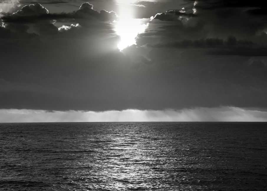The sunsets on the ocean, while a storm brews in the distance. This photograph can be enlarged to any size and can be a reminder in your home office of the wonders of nature.
