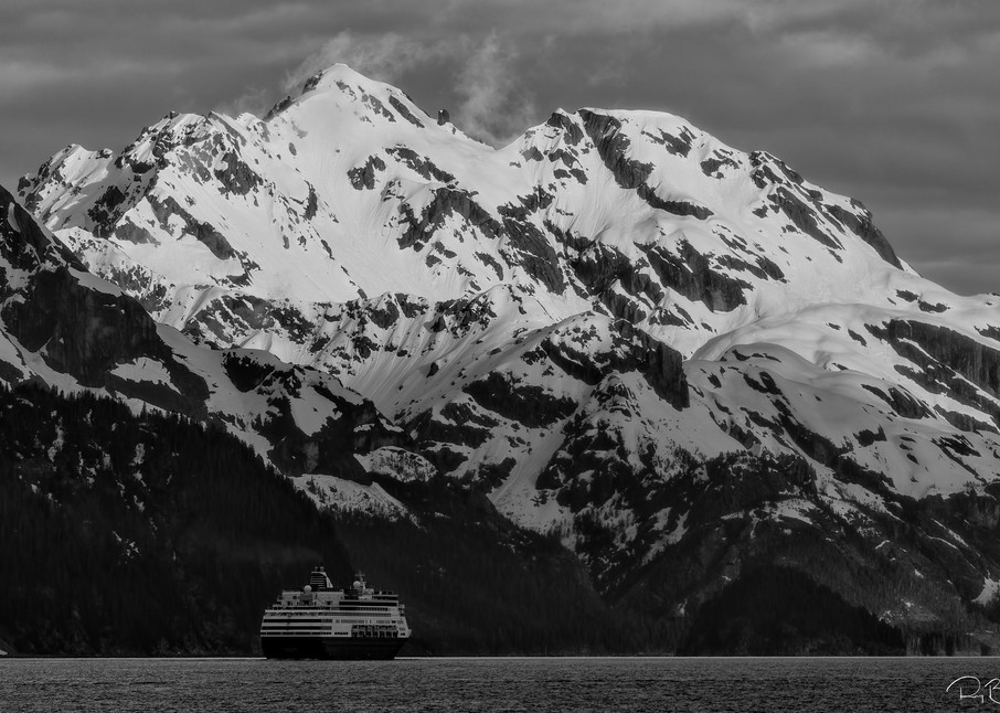 A cruise ship heads out of Resurrection Bay with the Resurrection Mountains in the background as it departs Seward and the Kenai Peninsula in the evening in Southcentral Alaska. Spring.