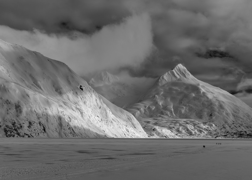 Hikers make the trek to Portage Glacier on Portage Lake in Southcentral Alaska. Winter. Afternoon.