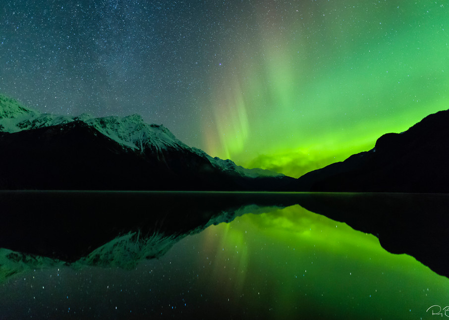 The aurora borealis is reflected in Chilkoot Lake near Haines in Southeast Alaska. Winter. Evening.