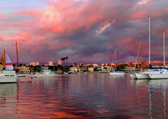 a panorama of boats in newport beach under red skies.
