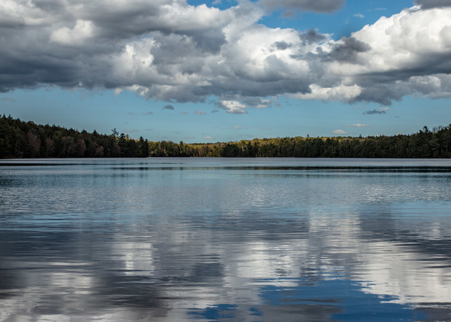 Late afternoon clouds are reflected in the mirrored waters of High Lake in Michigan's Sylvania Wilderness.