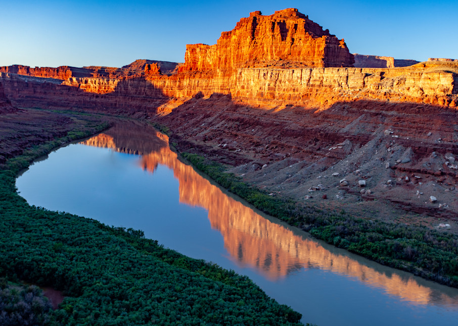 Rugged cliffs of Green River, Utah with the fiery glow of the setting sun.