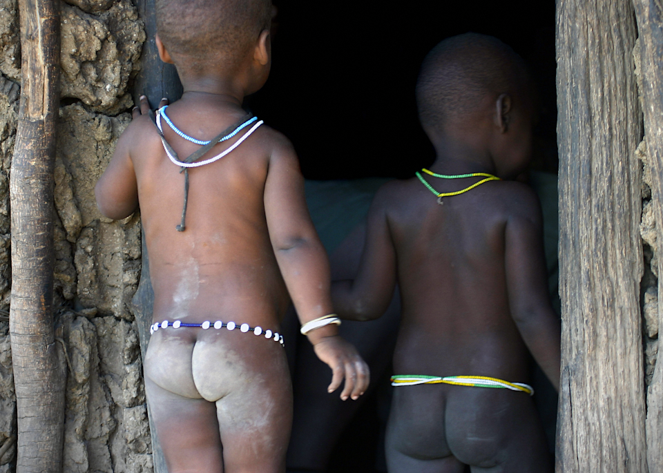 Datoga Datonga tribe Tanzania hut with two toddlers baby butts
