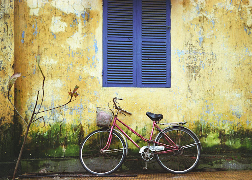 Bicycle Under Blue Shutter in French Vietnam under a Yellow Wall