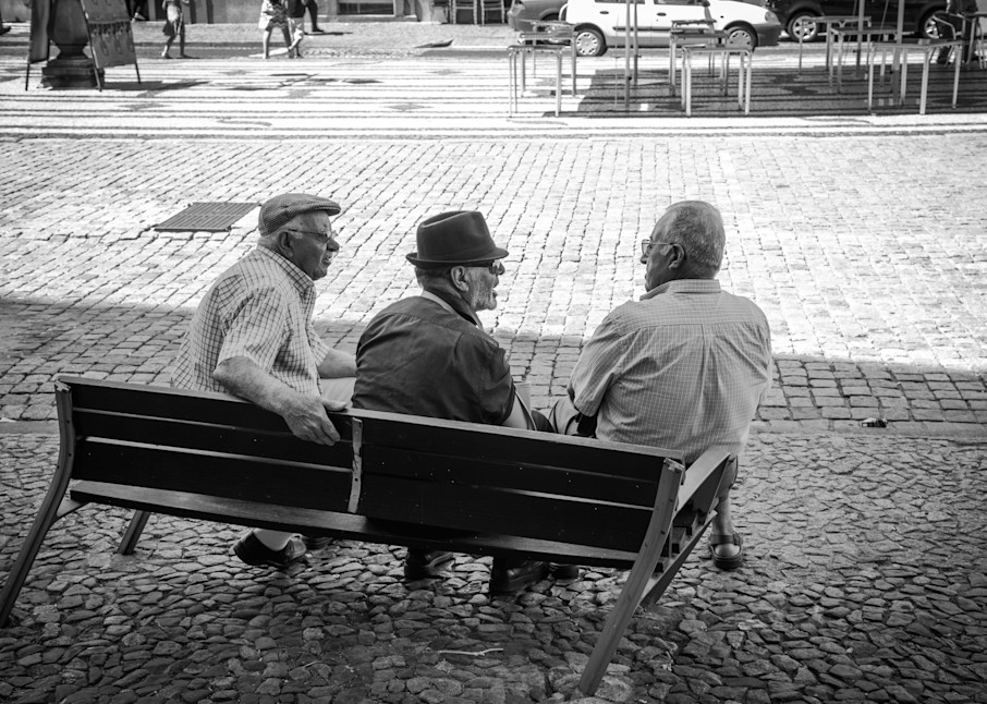 Old men converse on a broken bench