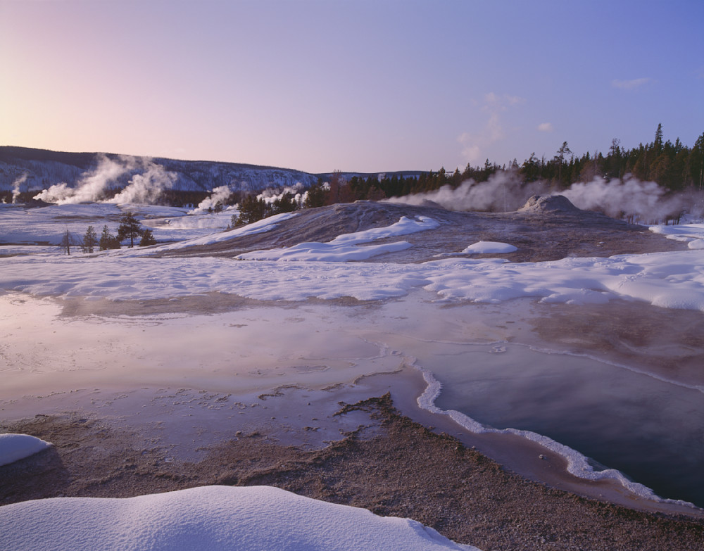 Snow and steam vents in Biscuit Basin in the evening, Yellowstone National Park, Wyoming