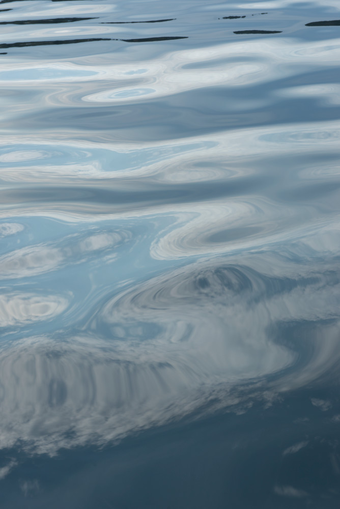 Fine art image of an abstract reflection scene of clouds on the surface by Greg Probst