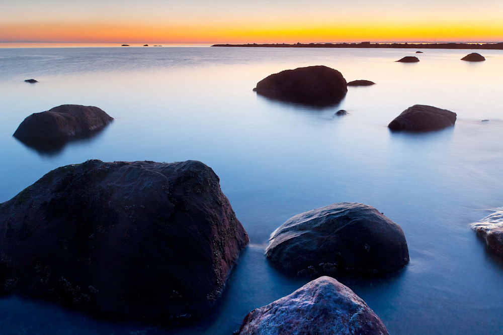 Peter Wnek photograph of the quiet water of Meigs Point at Hammonasset State park in Connecticut radiates in yellow and orange against the blue water of Long Island Sound.