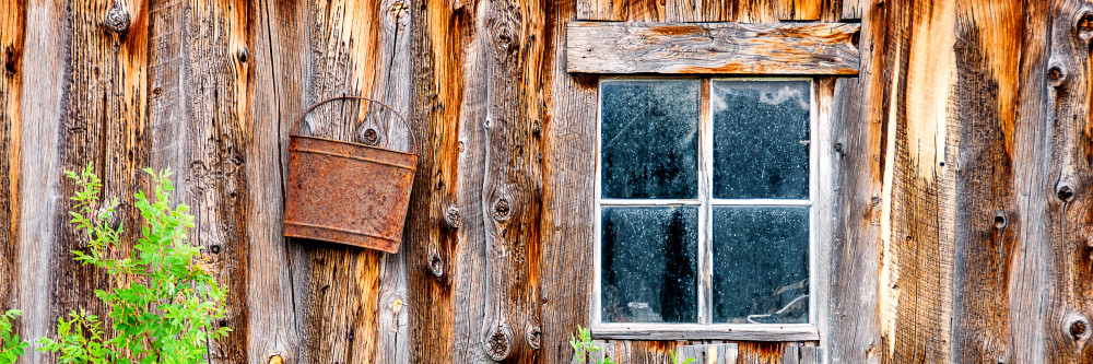 Art photograph, panorama of old bluish window on rustic brown barn