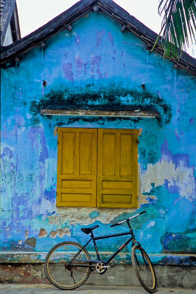 Bike in front of teal wall with mustard window
