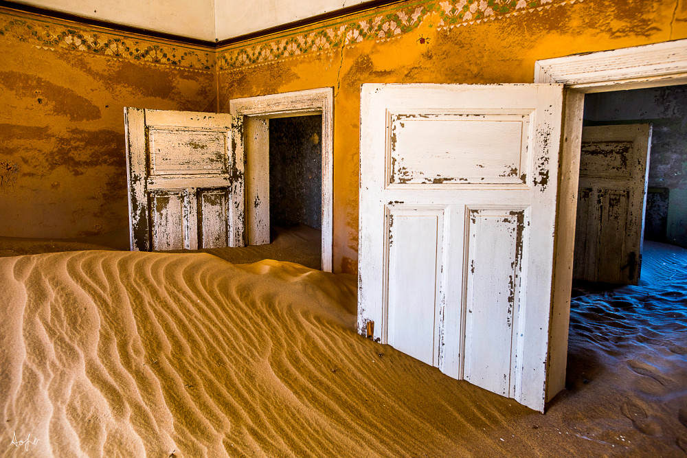 Surreal photograph art of old house filled with desert sand and morning light