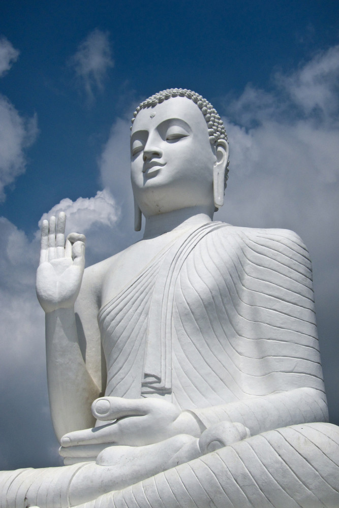 Large white buddha statue in sitting pose, in fine art photograph