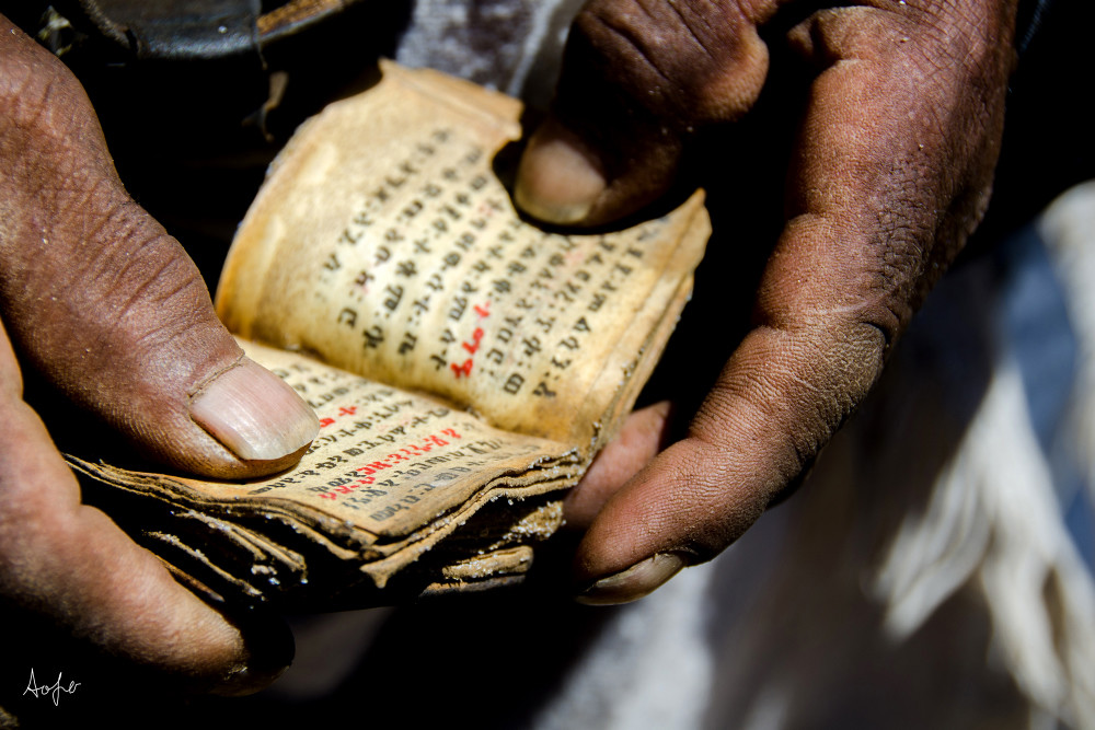 Fine art photograph of man holding a small leather Coptic bible