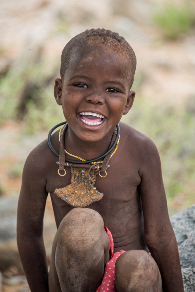 Smiling Himba girl with traditional jewelry
