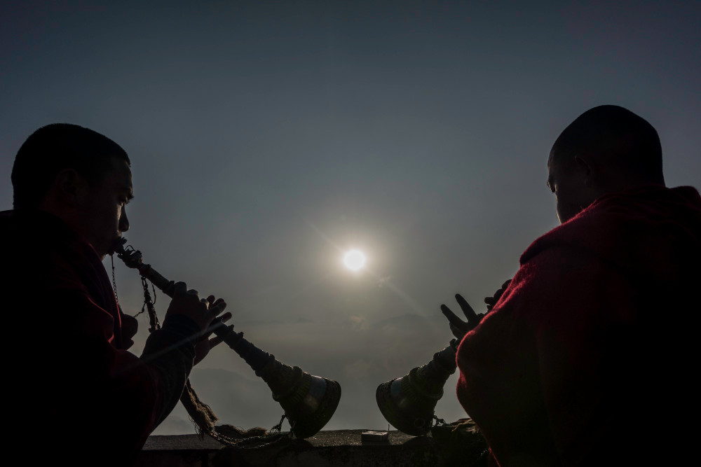 Tibetan monks playing the flute at sunrise