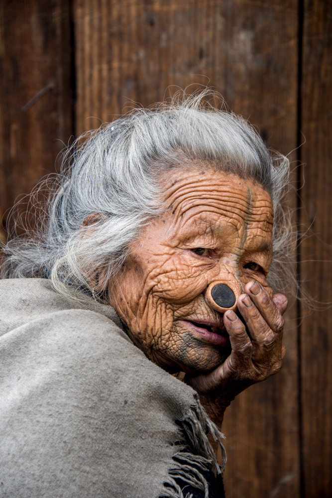 Portrait of old Apatani woman with face tattoo and nose plugs