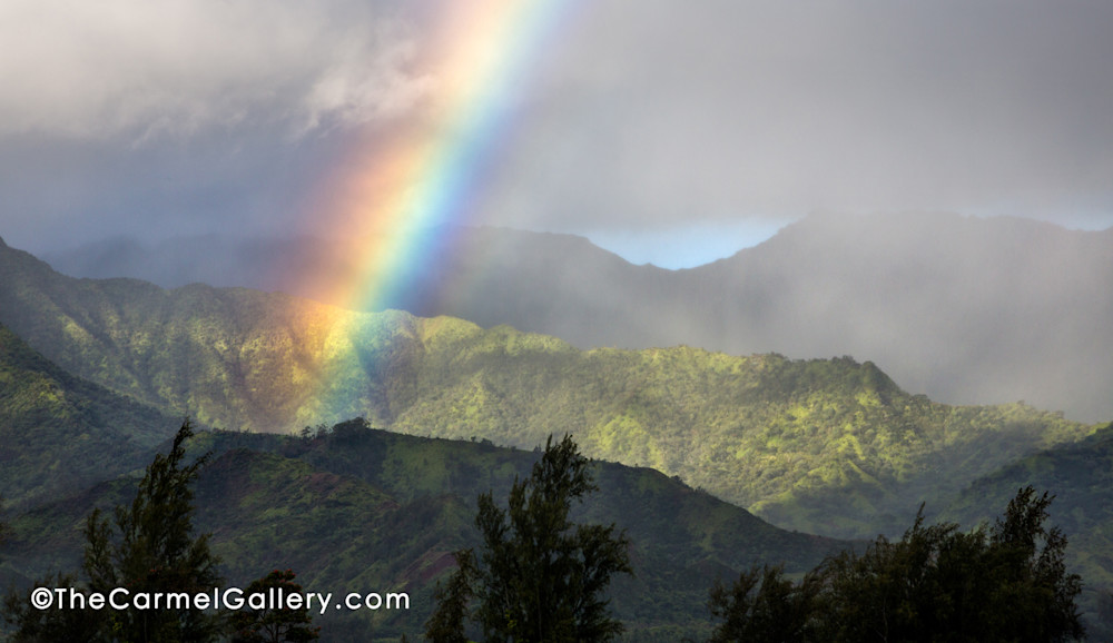 Early morning rain shower and rainbow over Hanalei Bay on Kauai