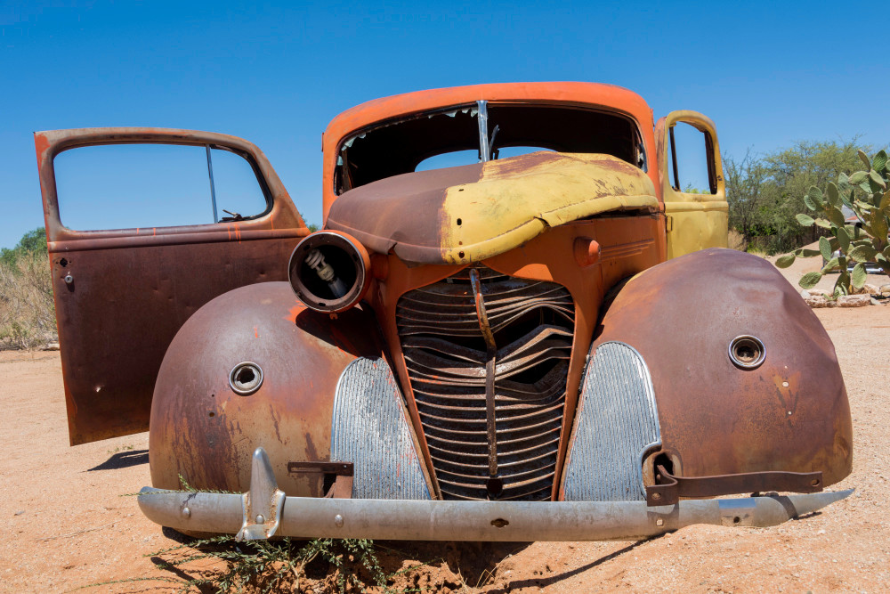 Front view of old Hudson car in the desert in photograph art