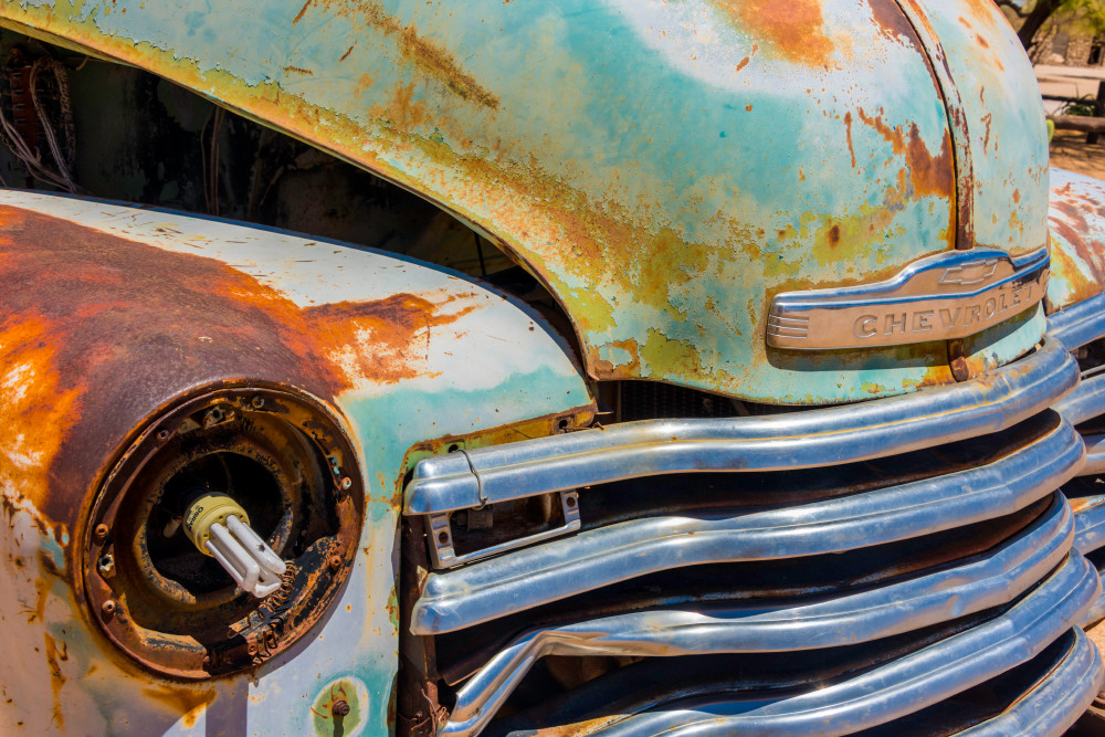 Close-up photograph art of old Chevrolet front grille with modern light bulb