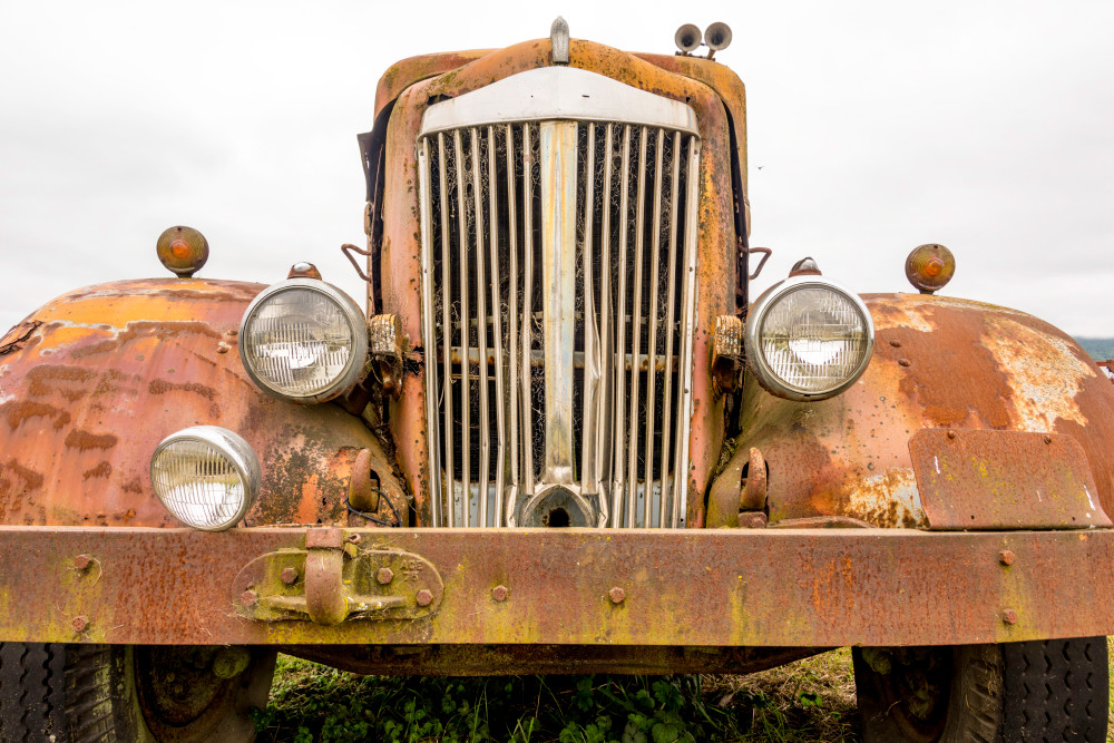 Wide angle of rusty antique car's classic front grille in art photograph
