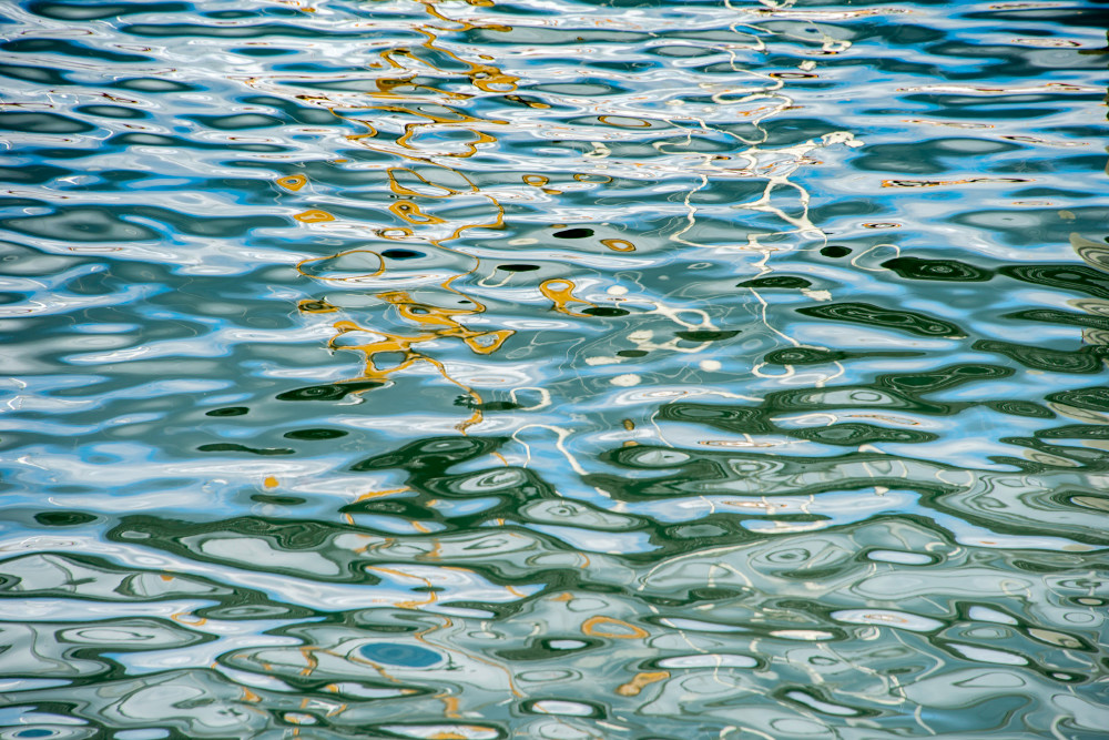 Fine art photograph, abstract reflections on water ripples in gold and blue