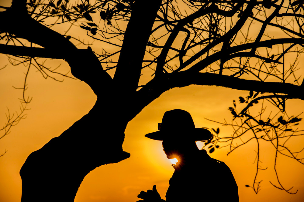 Silhouetted cowboy at sunset